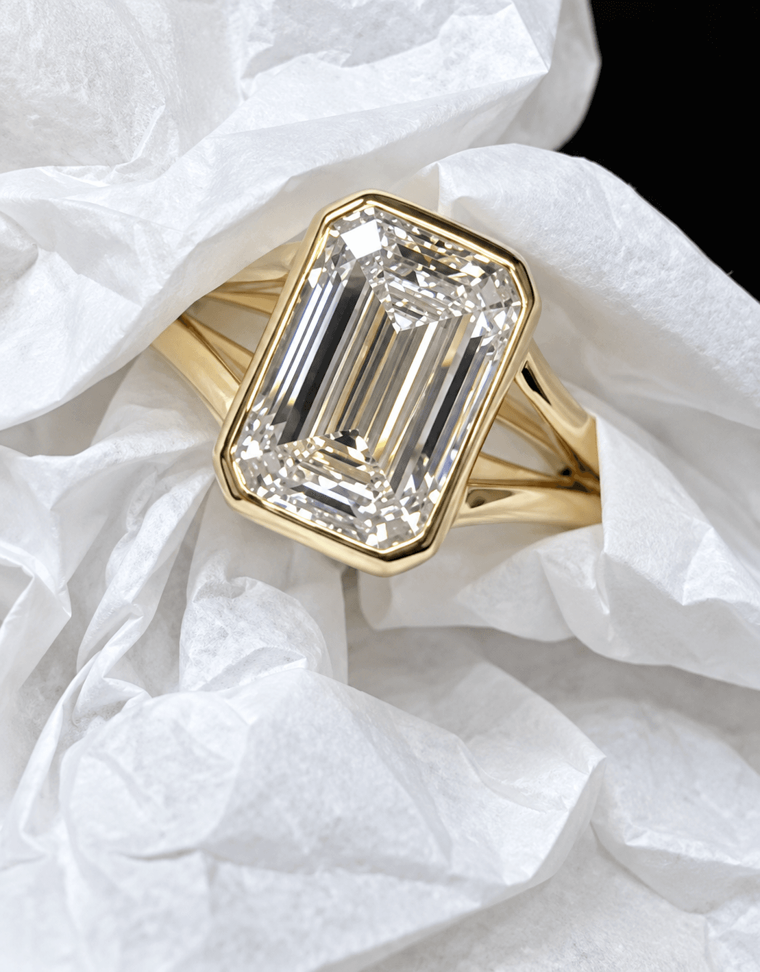Emerald cut diamond bezel ring in yellow gold