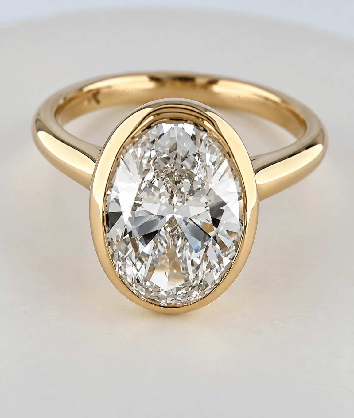 Oval diamond bezel ring in yellow gold
